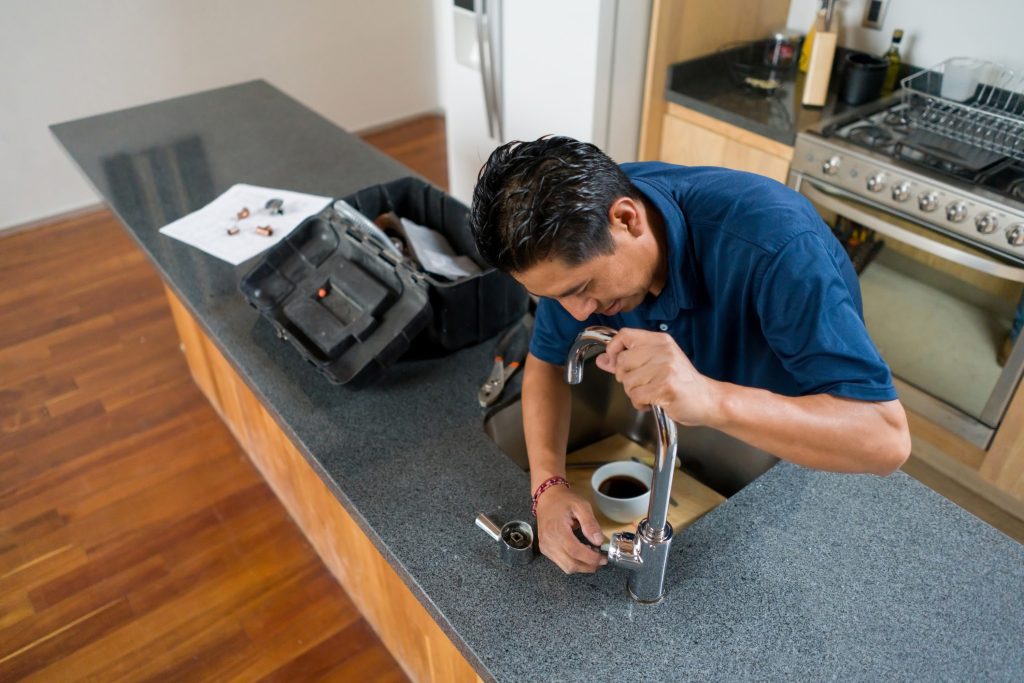 Close-up of a kitchen faucet being repaired